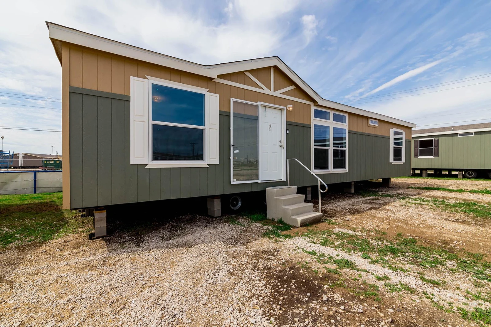 Double-wide manufactured home exterior with the base area ready for skirting