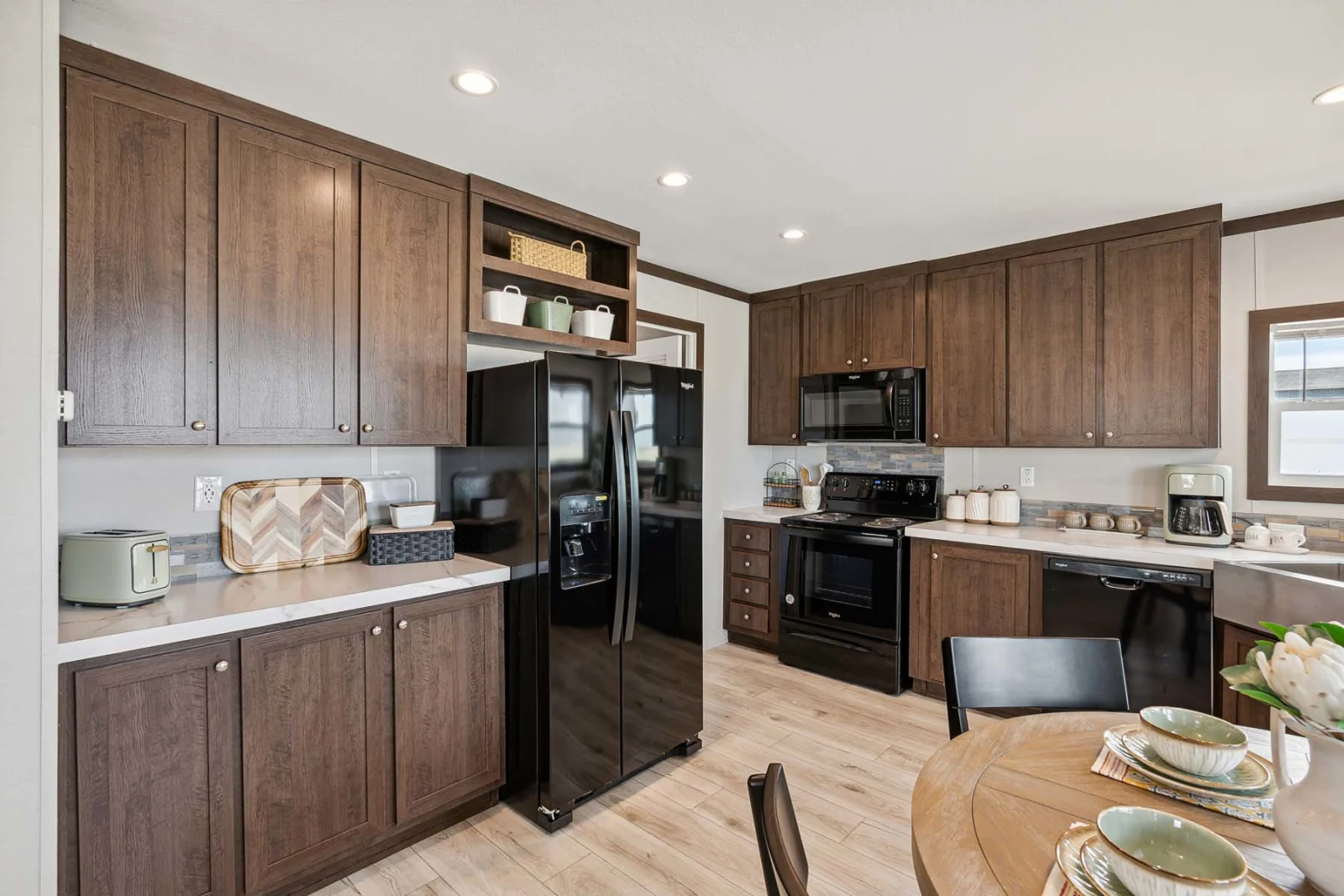 Modern kitchen cabinets and black appliances in The Rado tiny home