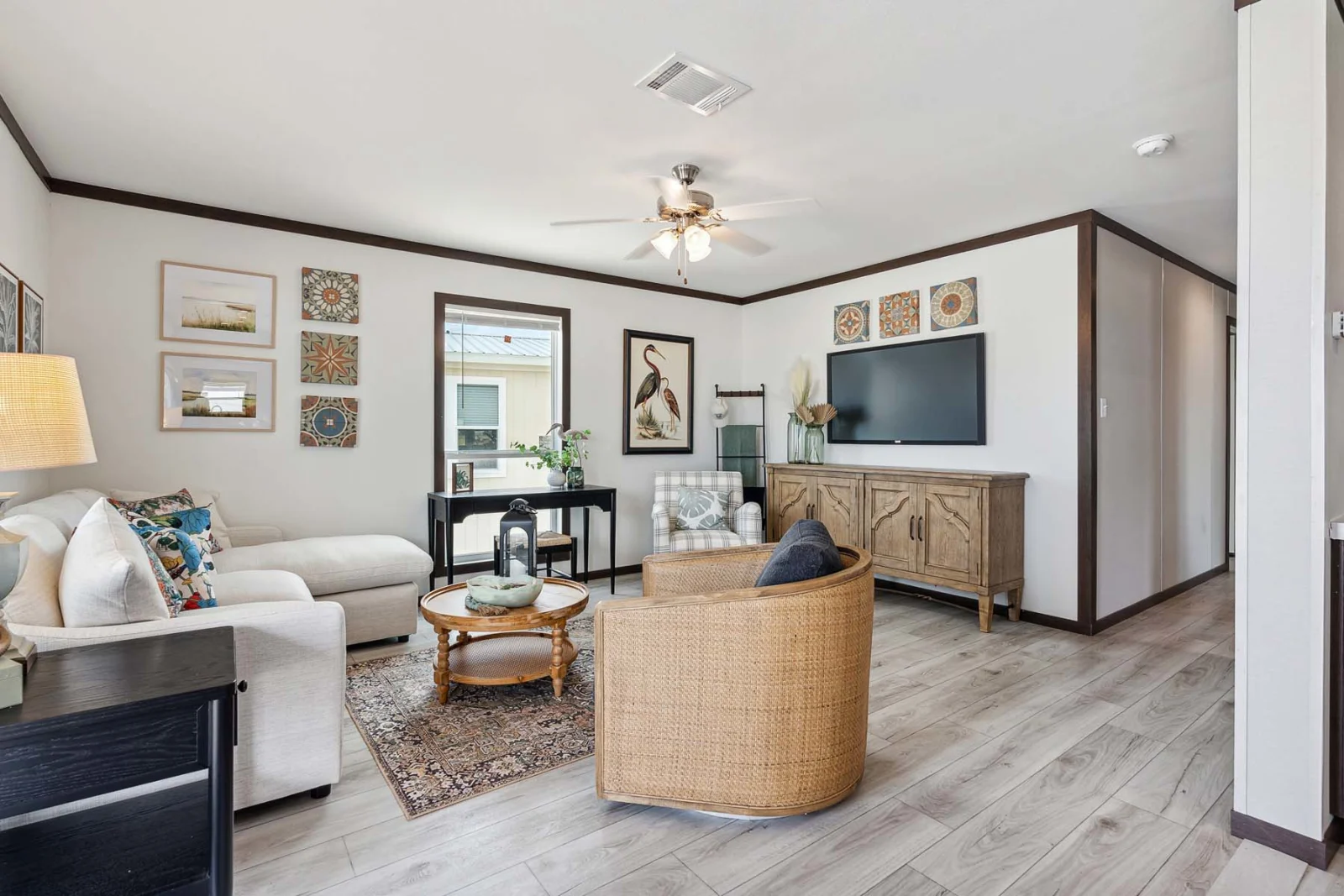 Living room with entertainment center and ceiling fan in The Rado tiny home