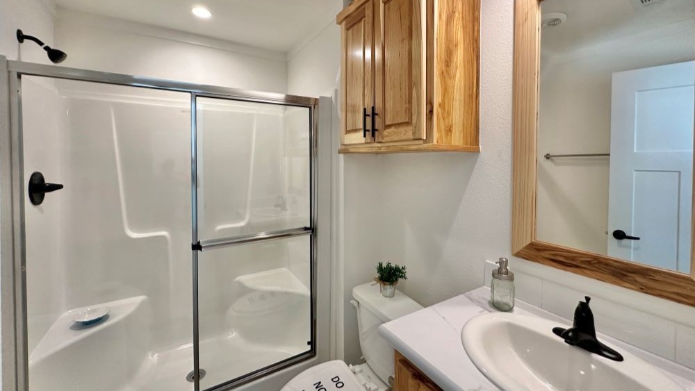 Secondary bathroom with full bathtub and shower in The Stealth tiny home plan.